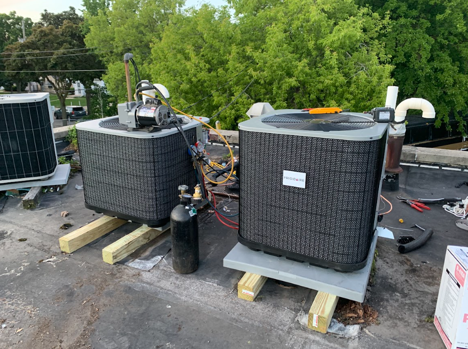 Two new condensers set on a rooftop with gauges attached